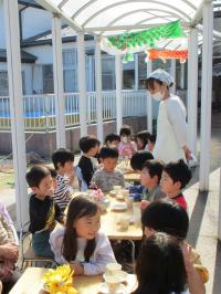 外でおやつを食べる年長児