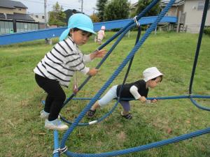 バランスを取りながら綱に登る１歳児