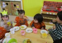 園で採れた、さつまいもで作ったスイートポテトを食べる１歳児