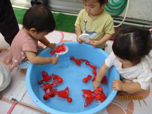 金魚すくいをする1歳児