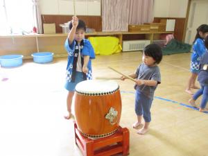 5歳児と一緒に太鼓に触れてみる2歳児