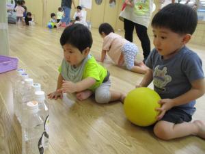 ボーリング遊びをする０歳児と２歳児