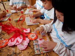 勤労感謝の日のプレゼントとしてペンダントを作る4歳児