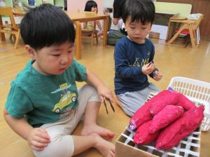 焼き芋ごっこをする2歳児