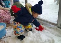 テラスに積もった雪に触れてみようとする０歳児