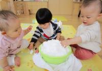 タライに入った雪で遊ぶ０歳児