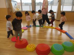 でこぼこ道を歩く多くの２歳児