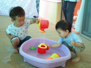 じょうろで水を流している１歳児